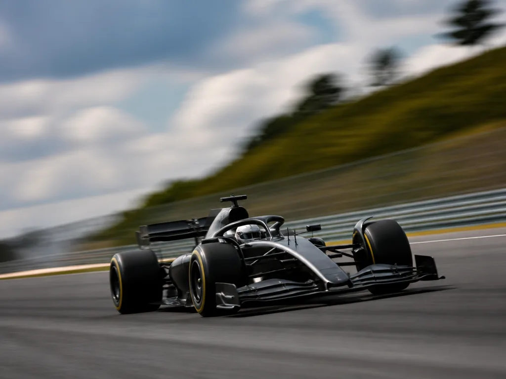 Formel 1-bil i hög hastighet på racerbana med rörelseoskärpa i bakgrunden